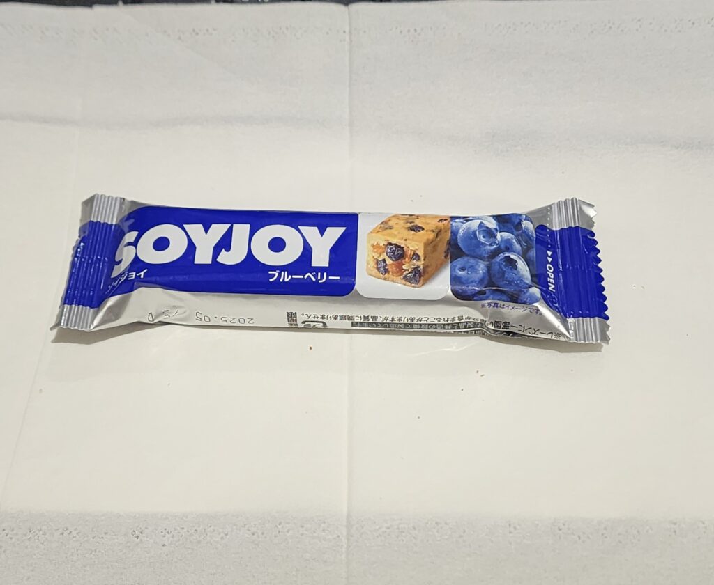 ファミリーマートで売ってる、小麦粉不使用の大豆粉生地に、ワイルドブルーベリーとホワイトチョコチップを練り込んだ低GI食品バーです。 今回レビューするのは、ファミ