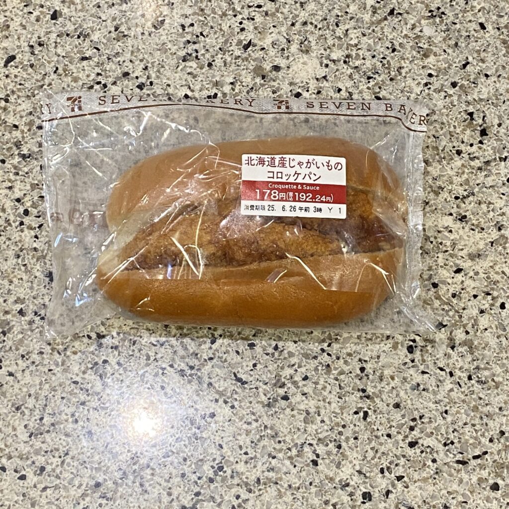 セブンイレブンのパンコーナーにて、定番すぎる惣菜パン【北海道産じゃがいものコロッケパン】を買いました。 まず、見た目のサイズ感からしておかしい！ですよね。 あま