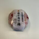 セブンイレブンで購入した「紀州南高梅使用 カリカリ梅おむすび」。見た目から鮮やかなピンク色が混ざり込んでいて、開けた瞬間から食欲をそそります！ ご飯全体に梅がち