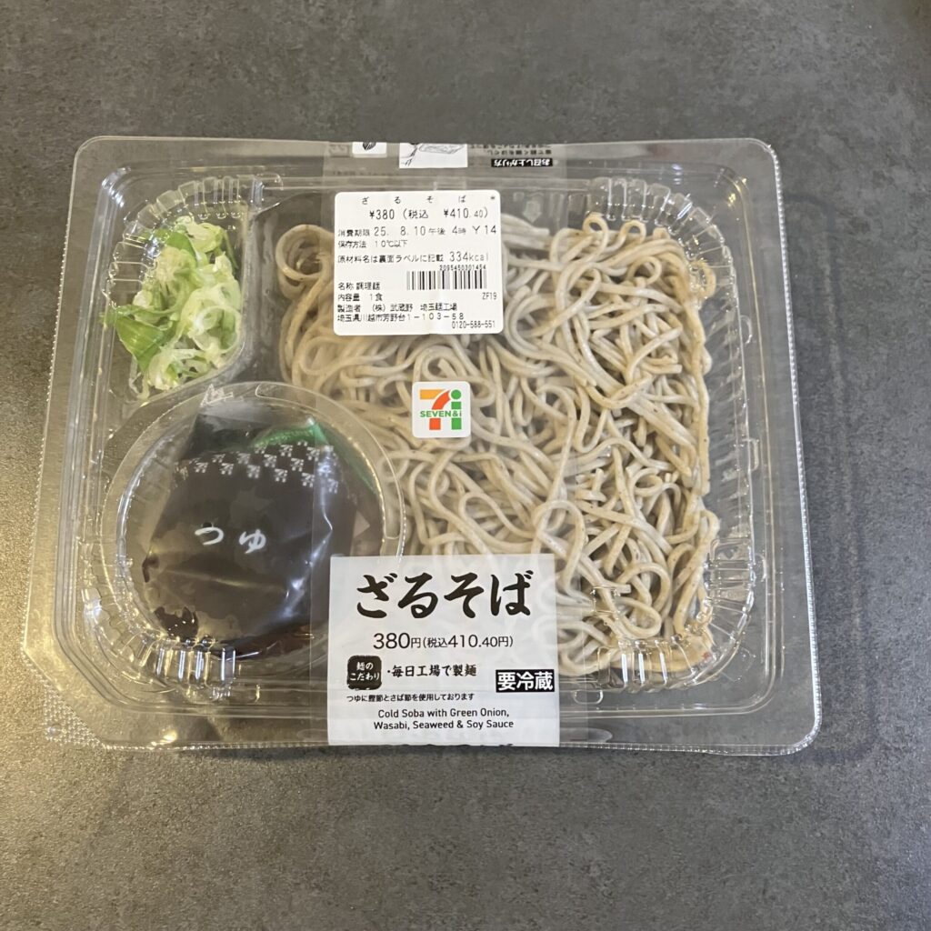 セブンイレブンで購入した「ざるそば」は、シンプルながらも安心感のある一品です！ 透明のパックを開けると、つややかなそばと刻み海苔の香りがふわりと広がり、付け合わ