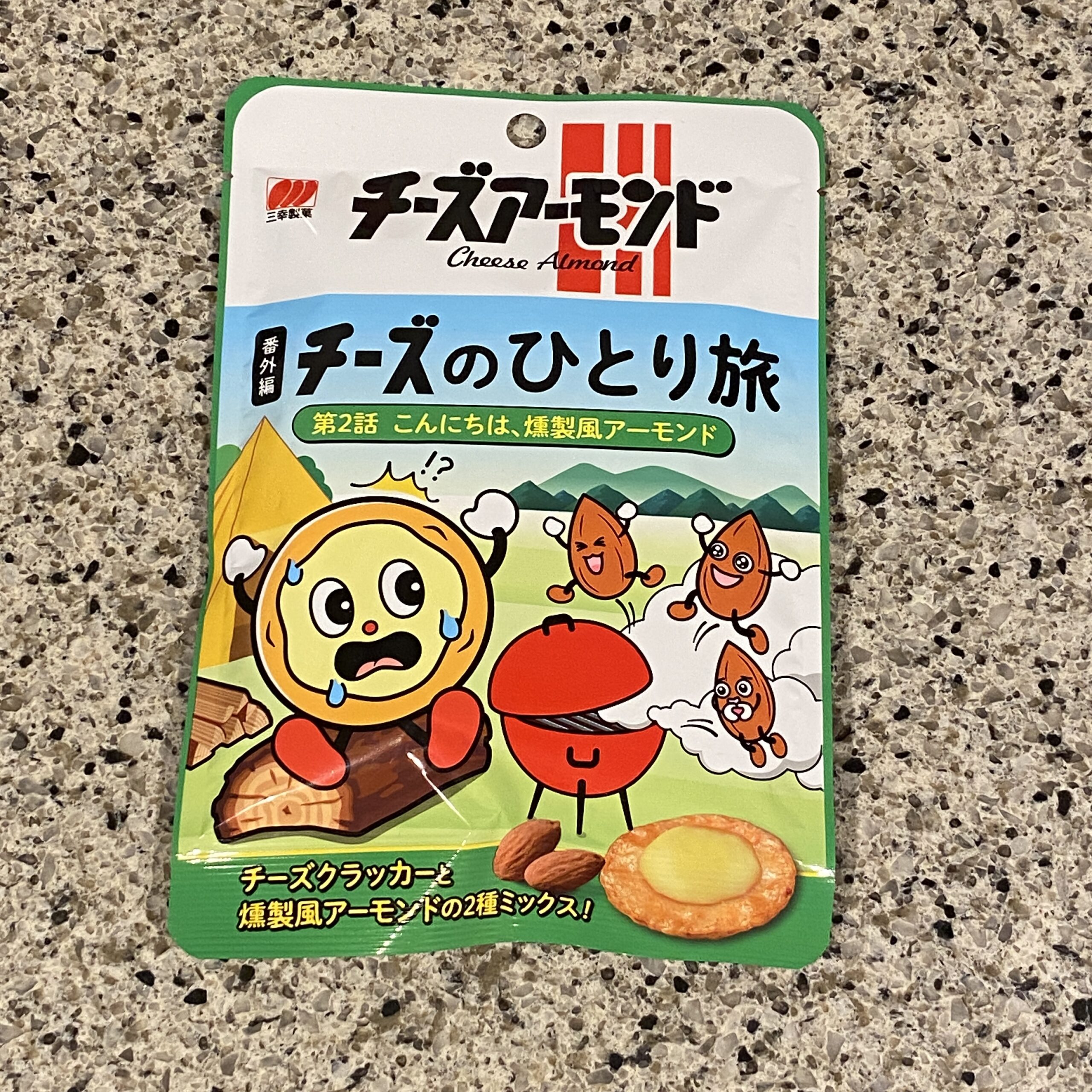 セブンイレブンのお菓子コーナーのおせんべいなどの売り場でみつけた【三幸製菓 チーズのひとり旅 燻製風アーモンドミックス】を買ってみました。 先日買ってみておいし