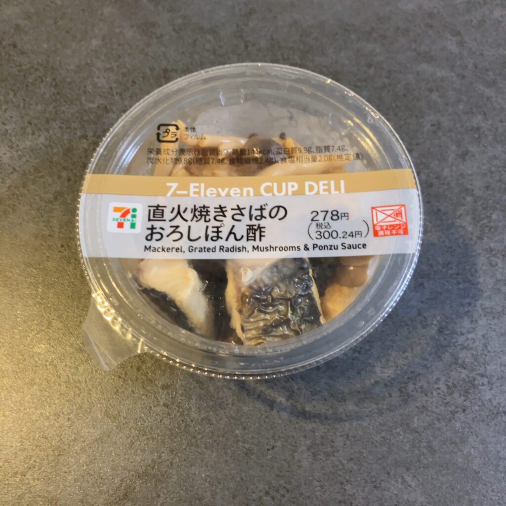 セブンイレブンで購入した「直火焼きさばのおろしぽん酢」は、小さなカップに入っていながら本格的な味わいが楽しめる一品でした。 フタを開けると、香ばしく焼かれた鯖の